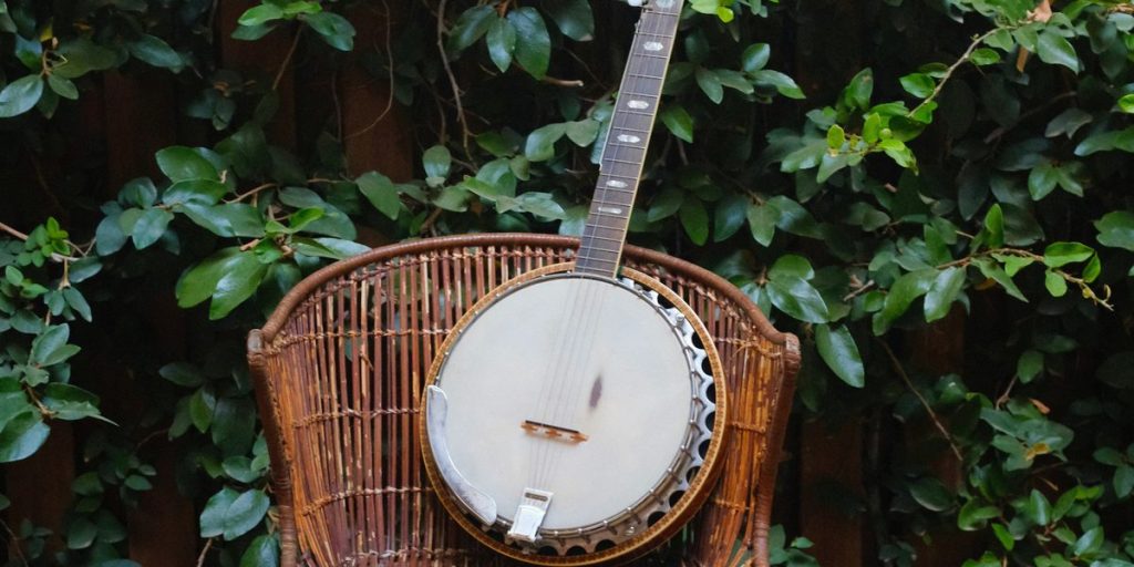 Five-string banjo resting on a wicker chair