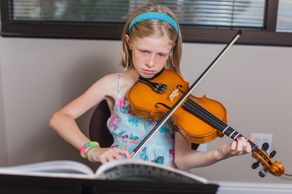 Young student reading music during a violin lesson in Colorado Springs