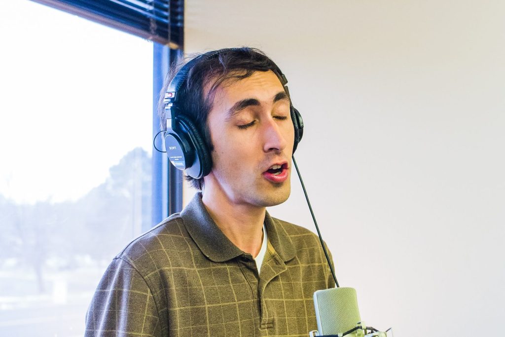 Voice student singing into a studio microphone during a voice lesson in Colorado Springs